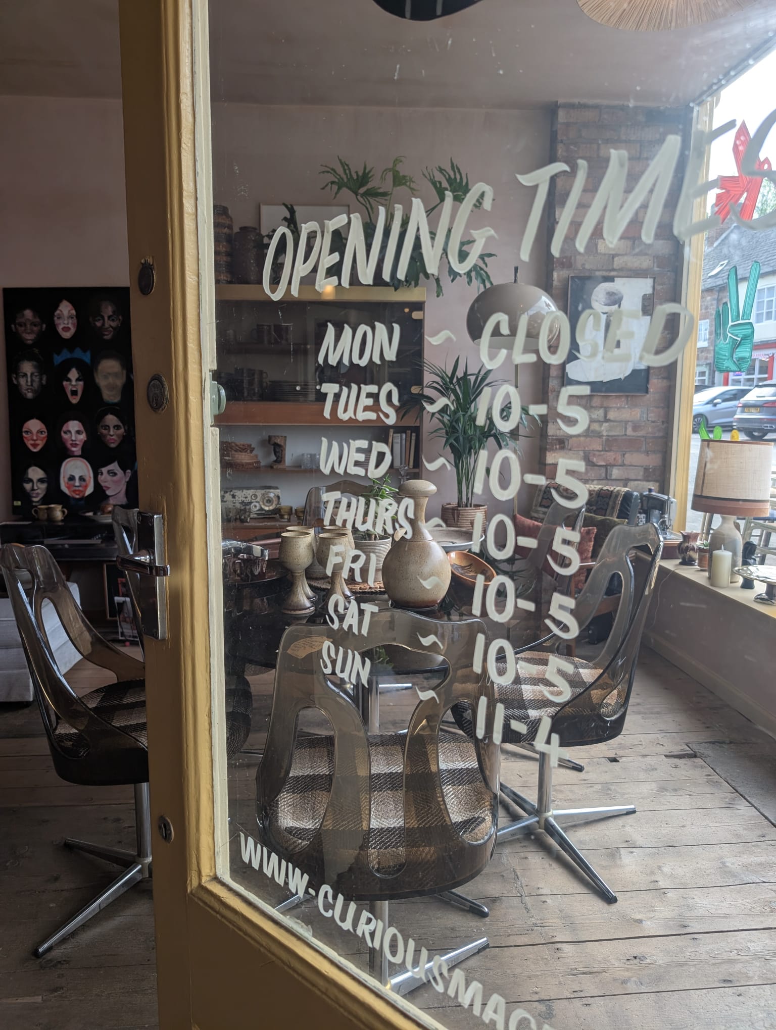 Hand-painted opening times on the Curious Magpie front door